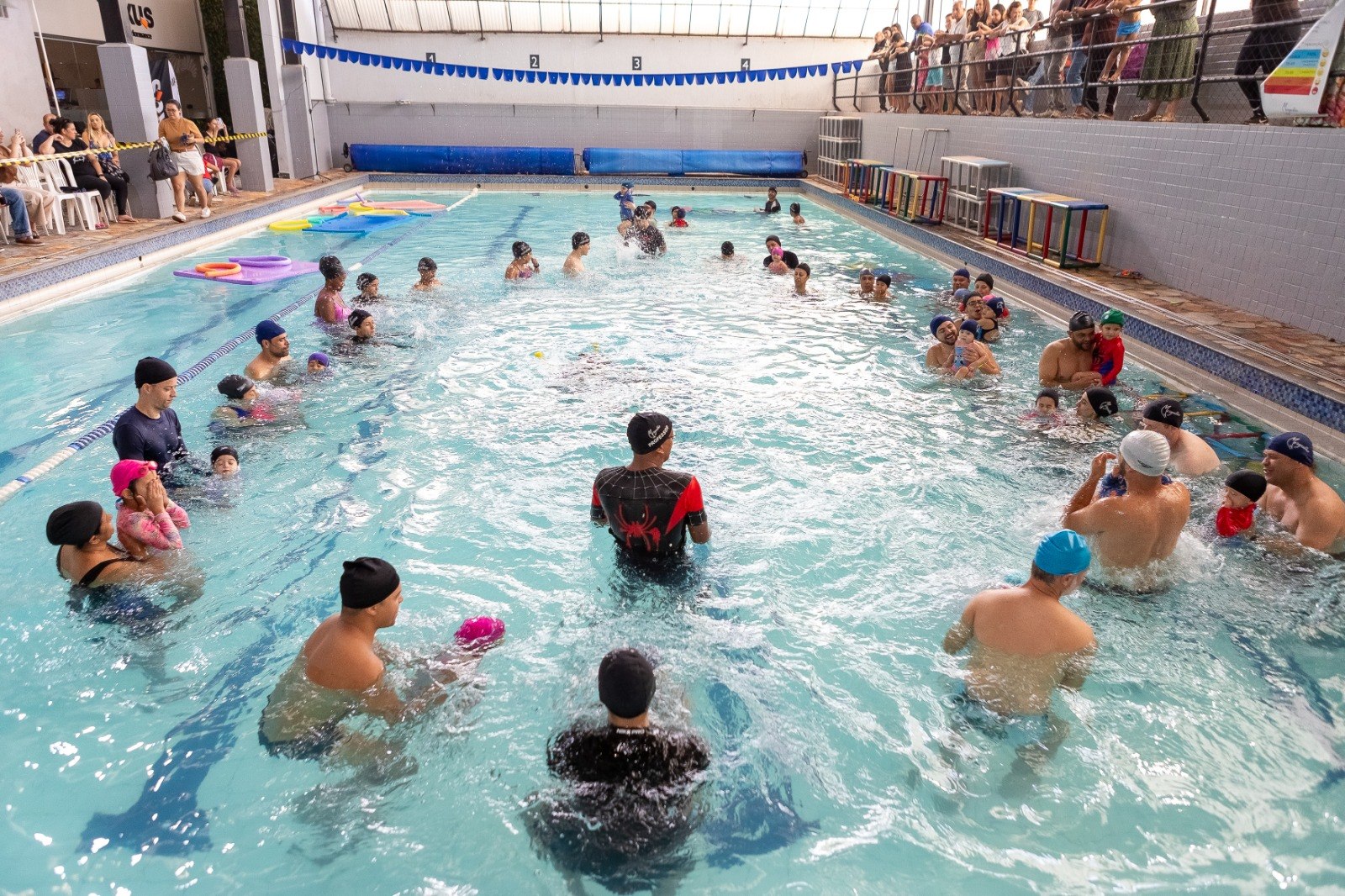 Famílias participando de atividade na piscina da Academia Mergulho